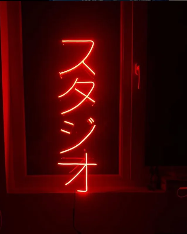 Red neon sign in Japanese script reading studio