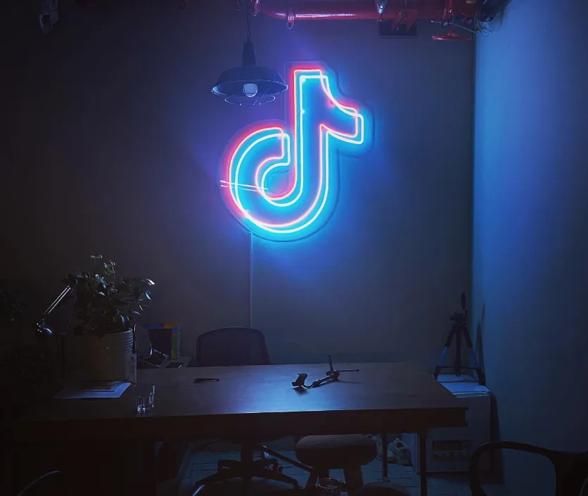 TikTok logo LED neon sign on an office wall