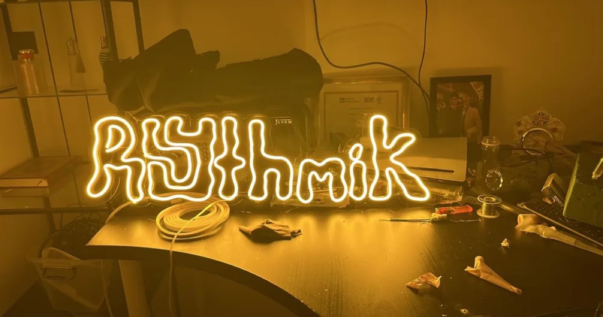 Yellow Rhythmik neon sign on a workbench
